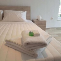 Panorama House 9 Panorama House – διπλό κρεβάτι με λευκά λινά, πετσέτες & amenities δίπλα στο παράθυρο