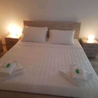 Panorama House 8 Panorama House – υπνοδωμάτιο με διπλό κρεβάτι, κομοδίνα με φωτιστικά και σετ πετσετών