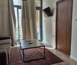 Lux Studio 365 V1 1 Καθιστικό με καναπέ, χαλί και τραπεζάκι μπροστά από την μπαλκονόπορτα στο Lux Studio 365