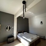 365 Studio 9 Διπλό κρεβάτι με λευκά σεντόνια και διακριτικό φωτισμό.