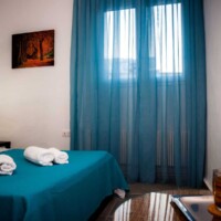 Aegean View Villa 15 Aegean View Villa – Διπλό κρεβάτι με κομοδίνα και επιτραπέζια φωτιστικά, θαλασσινή διακόσμηση