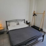 Castle View Studio Kavala 6 Minimal υπνοδωμάτιο με φυσικό φως και ήρεμη αισθητική.