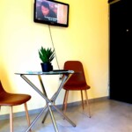 Άνετη διακόσμηση με τηλεόραση και τραπεζάκι, ιδανική για χαλάρωση και διασκέδαση στην Καβάλα, σε άνετο εσωτερικό χώρο. Ψηφιακή τηλεόραση σε εσωτερικό δωμάτιο Kavala Stay, άνετο τραπέζι με φυτά, φωτεινή διακόσμηση, ιδανικό για διαμονή και χαλάρωση στην Καβάλα.