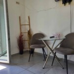 Castle View Studio Kavala 4 Άνετο σαλόνι στο Castle View Studio στην Καβάλα γωνία με τραπεζάκι και καρέκλες με σύγχρονη διακόσμηση και πρόσβαση στο μπαλκόνι με θέα.