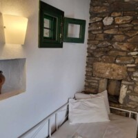 Kaliva Luxury Villa 10 Kaliva Luxury Villa – Καθιστικό με πέτρινο τοίχο και διακοσμητικούς πίνακες