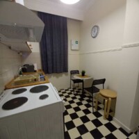 Harmony Apartment 12 Κουζίνα με τραπεζάκι για δύο και καρό δάπεδο στο Harmony Apartment, Καλαμίτσα.