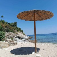 Harmony Apartment 18 Παραλία με ψάθινη ομπρέλα και γαλάζια θάλασσα δίπλα στο Harmony Apartment.