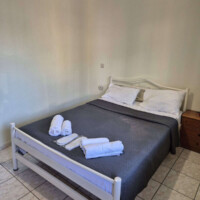 Old Town Apartment 7 Διπλό κρεβάτι με παράθυρο και κουρτίνες σε φωτεινό υπνοδωμάτιο διαμερίσματος στην Καβάλα