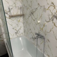 Depys Apartment 7 Modern bathtub with shower in marble style bathroom in apartment in Kavala Greece