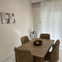 Depys Apartment 6 Dining area with wooden table and chairs in modern apartment in Kavala Greece.