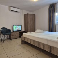 Υπνοδωμάτιο με διπλό κρεβάτι και τηλεόραση στο Blue Apartment Kavala
