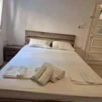Διπλό κρεβάτι με πετσέτες στο Blue Apartment Kavala
